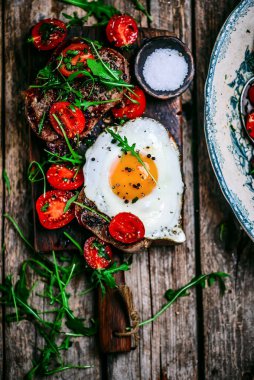 Kızarmış yumurta ve kiraz domatesli Toskana bifteği. Tarz rustik. Seçici odak noktası.