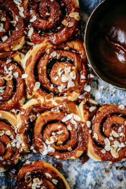 Brunost karamelli tarçınlı çörekler ahşap bir masa. Koyu kırsal fotoğraf. Seçici odaklanma.