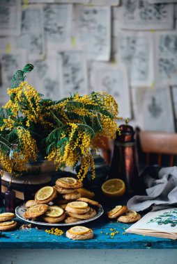 Limonlu bisküvi ve bir buket mimoza... stil vintage.Seçici odak noktası
