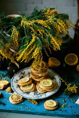 Limonlu bisküvi ve bir buket mimoza... stil vintage.Seçici odak noktası