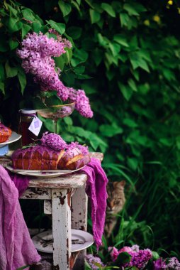 Bahar bahçesindeki bir masada lavanta rengi pasta... stil vintage.Seçici odak