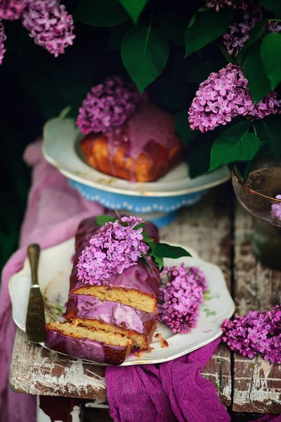 春の庭のテーブルの上にラベンダー釉薬ケーキ スタイルのブドウ — ストック写真