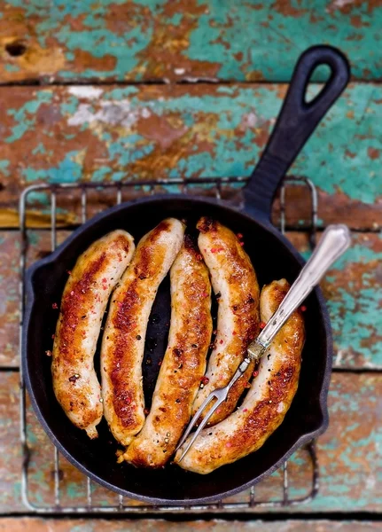 Fried sausages on a frying pan — Stock Photo, Image