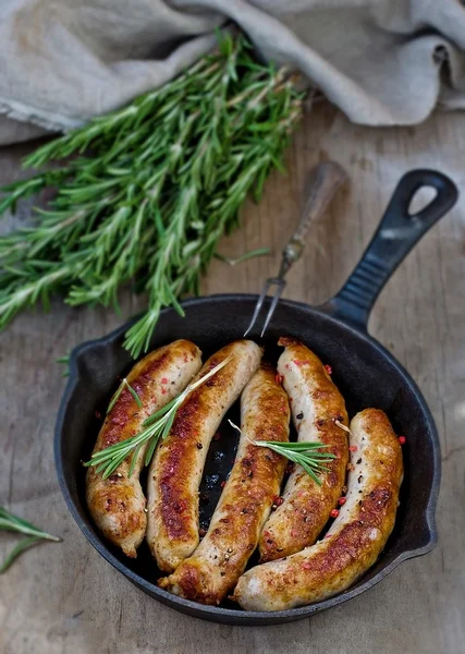 Fried sausages on a frying pan — Stock Photo, Image