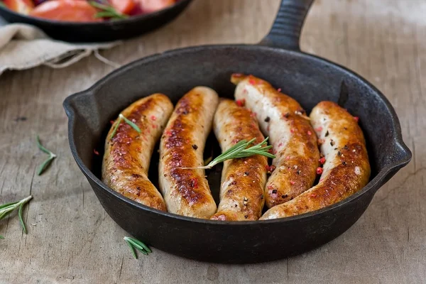 Fried sausages on a frying pan — Stock Photo, Image