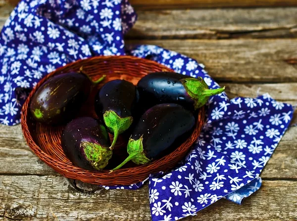 Berenjenas frescas y orgánicas en una cesta de mimbre —  Fotos de Stock