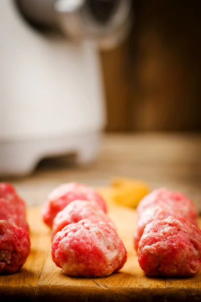 Raw meat balls on a chopping board. — Stock Photo, Image