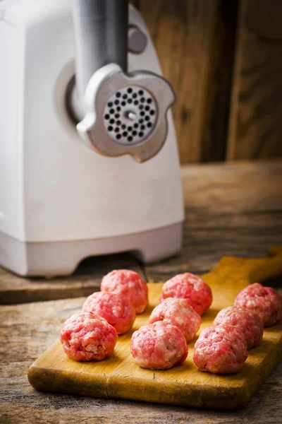 Boulettes de viande crue sur une planche à découper . — Photo