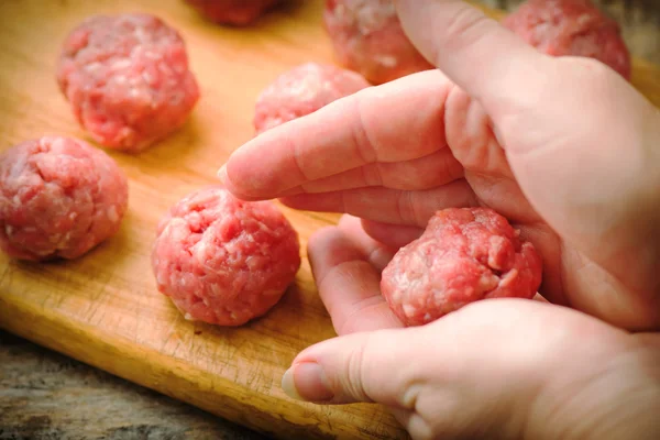 Bolas de carne cruda en una tabla de cortar . —  Fotos de Stock