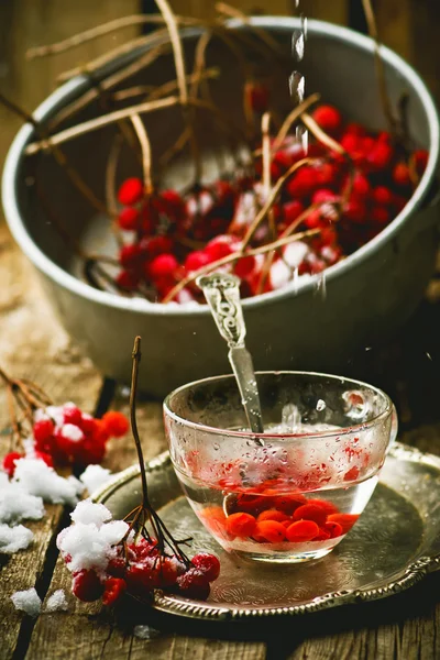 Friss bogyós gyümölcsök a guelder-Rózsa a egy fából készült asztal üveg pohár. — Stock Fotó