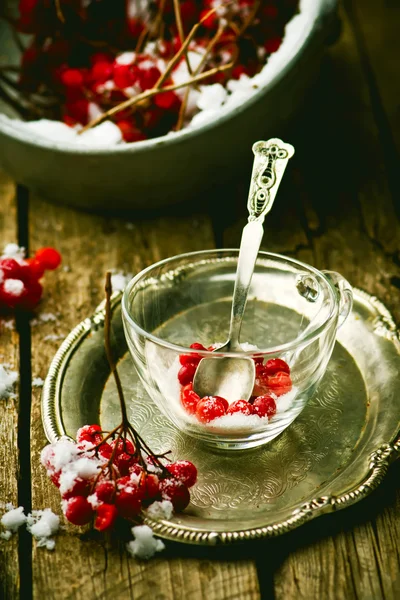 Bayas frescas de una rosa guelder en una taza de vidrio sobre una mesa de madera . — Foto de Stock