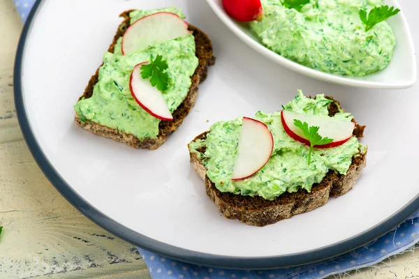 Canapé com queijo de casa de campo, verdes e um rabanete de jardim . — Fotografia de Stock