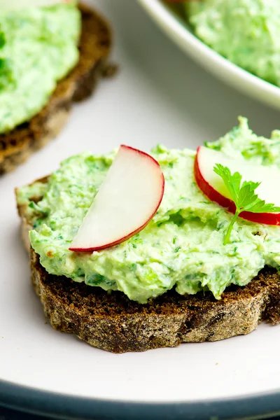 Canapé com queijo de casa de campo, verdes e um rabanete de jardim . — Fotografia de Stock