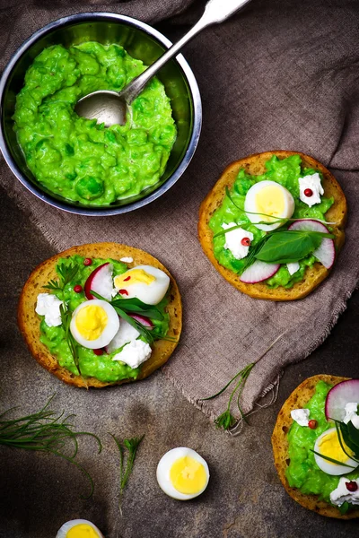 Canapé con pasta de guisantes verdes y huevos Imagen de stock