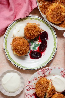 Geleneksel Avusturya süzme peynirli hamur köfteleri erik kompostosu ve ekşi krema ile. Top veiw.style sarılma. Seçici odak noktası