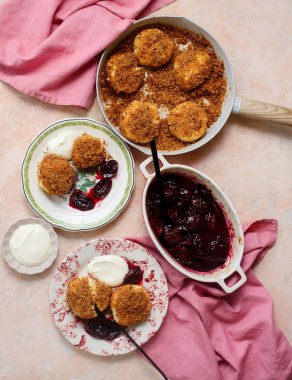 Geleneksel Avusturya süzme peynirli hamur köfteleri erik kompostosu ve ekşi krema ile. Top veiw.style sarılma. Seçici odak noktası