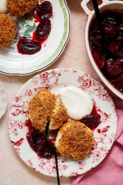 Geleneksel Avusturya süzme peynirli hamur köfteleri erik kompostosu ve ekşi krema ile. Top veiw.style sarılma. Seçici odak noktası