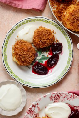 Geleneksel Avusturya süzme peynirli hamur köfteleri erik kompostosu ve ekşi krema ile. Top veiw.style sarılma. Seçici odak noktası