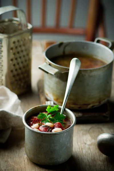 Sopa de feijão e salsichas e caneca de metal . — Fotografia de Stock