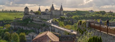 Kamianets-Podilskyi Kalesi 'nin arka plan manzarası. Turistler ön planda şatonun arka planında Ukrayna ile selfie çekiyorlar..