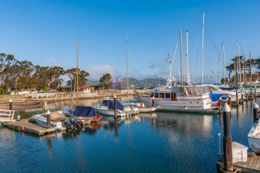 Marina manzaralı ön planda demirli yatlar, arka planda Golden Gate Köprüsü küçük, güzel bulutlar, Kaliforniya, ABD