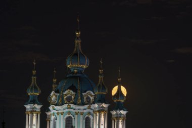 Dolunay, Ukrayna, Kiev 'deki St. Andrew Kilisesi' nin kulesinde parlıyor.