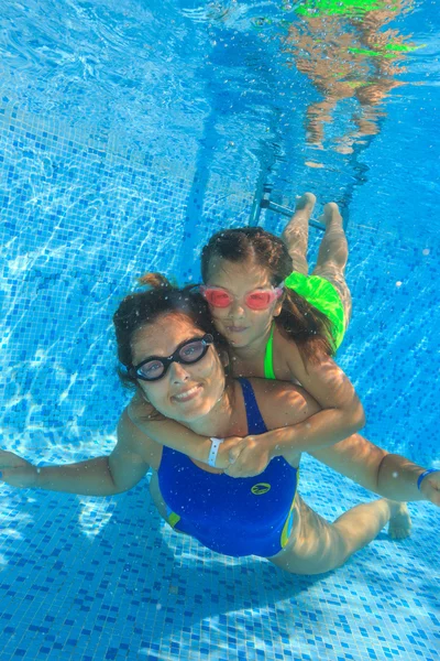 Mother and daughter dive in the swimming pool — Stock Photo, Image