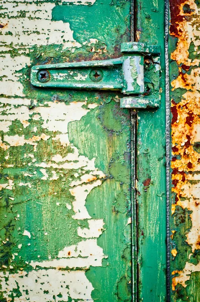 Hinge on rusty metal door with cracked paint — Stock Photo, Image