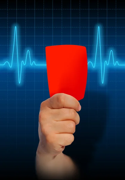 Hand holding red card on heart rate monitor — Stock Photo, Image