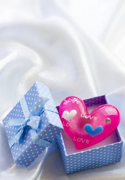 Blue present box with pink heart of glass in it — Stock Photo, Image