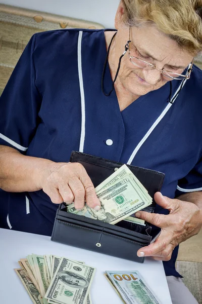 Pensioner holding wallet with money — Stock Photo, Image