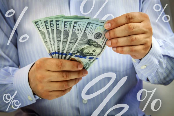 Handen tellen van geld met procenttekens rondzweven — Stockfoto