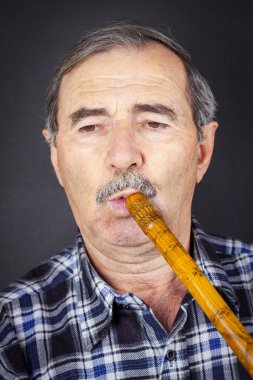 Boru flüt üzerinde oynayan adam