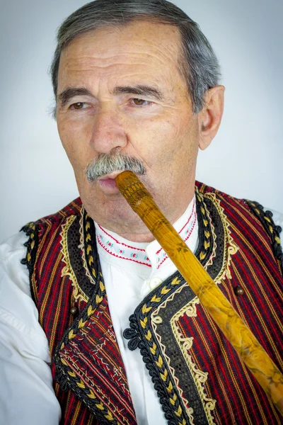 Pipe player in traditional clothing — Stock Photo, Image