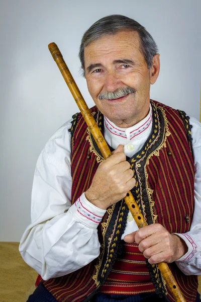 Pipe player in traditional clothing — Stock Photo, Image