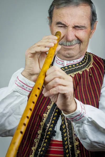 Pipe player in traditional clothing — Stock Photo, Image