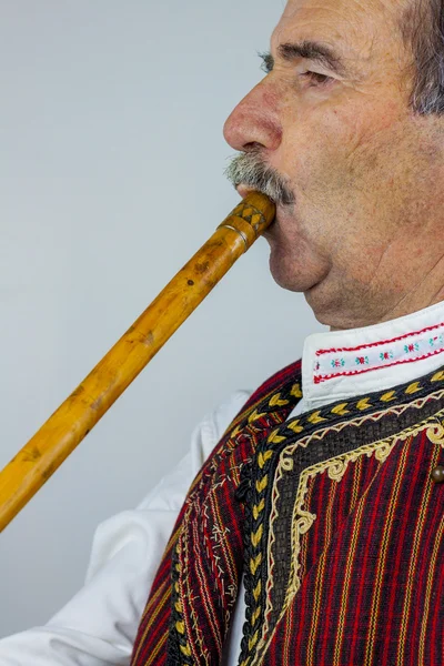 Pipe player in traditional clothing — Stock Photo, Image