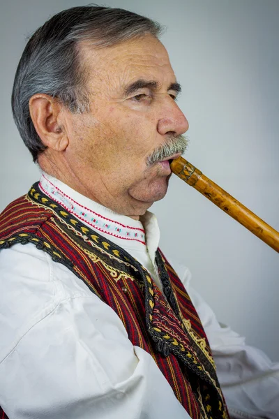 Pipe player in traditional clothing — Stock Photo, Image