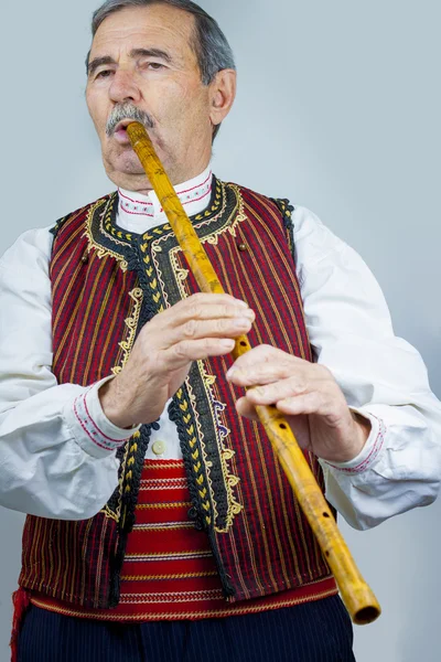 Pfeifenspieler in traditioneller Kleidung — kostenloses Stockfoto