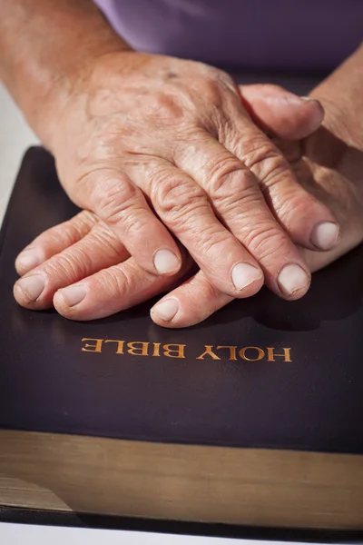 Las manos de una anciana en la Sagrada Biblia —  Fotos de Stock