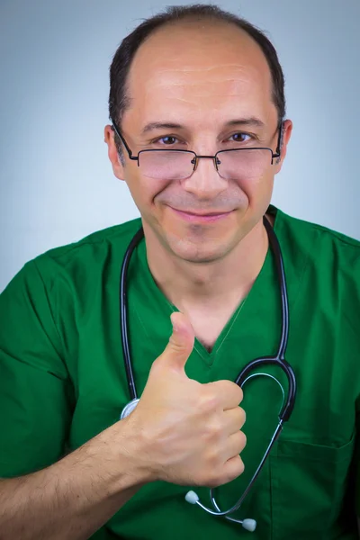 Retrato del médico en uniforme verde mostrando signo ok — Foto de Stock