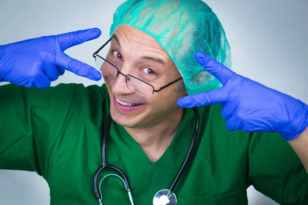 Médecin chirurgien montrant des ciseaux avec ses mains — Photo
