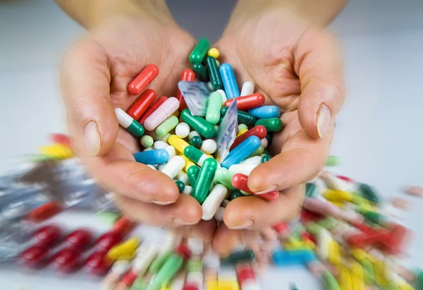 Mãos segurando um monte de comprimidos — Fotografia de Stock