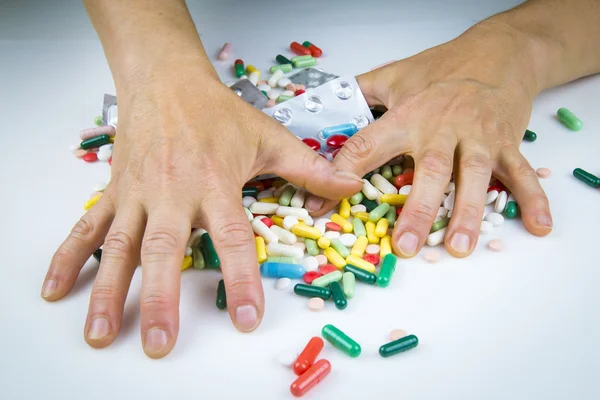 Mãos segurando um monte de comprimidos — Fotografia de Stock