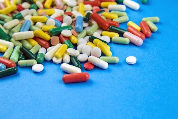 Lot of colorful pills on a blue background — Free Stock Photo