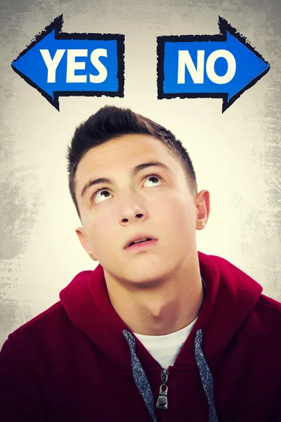 Teenage boy thinking what to choose between YES and NO — Stock Photo, Image