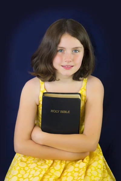 Retrato de una niña hermosa sosteniendo la Santa Biblia — Foto de Stock