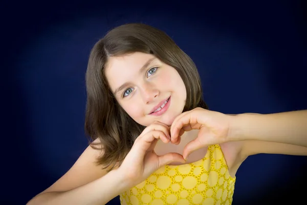 Retrato de hermosa niña mostrando la forma del corazón con su h —  Fotos de Stock