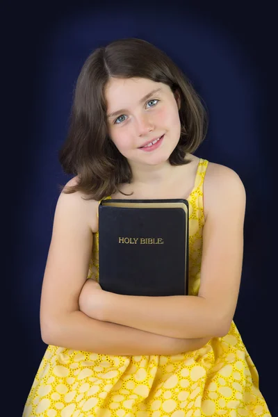 Портрет красивой маленькой девочки, держащей Библию Стоковое Фото