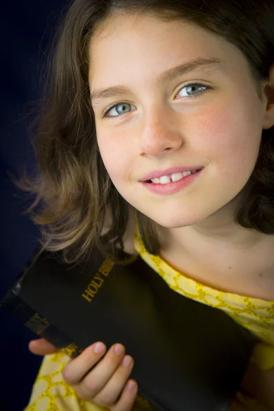 Портрет красивой маленькой девочки, держащей Библию Стоковая Картинка